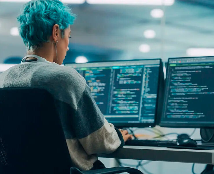 Persona trabajando en ordenadores