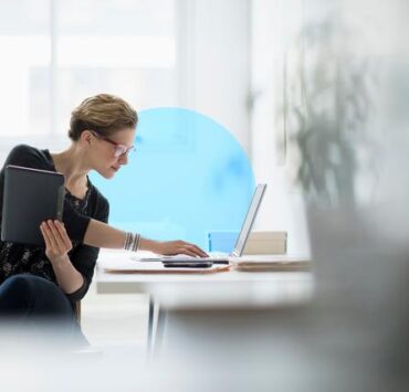 Empresaria con ordenador portatil en la oficina Business woman using laptop in office